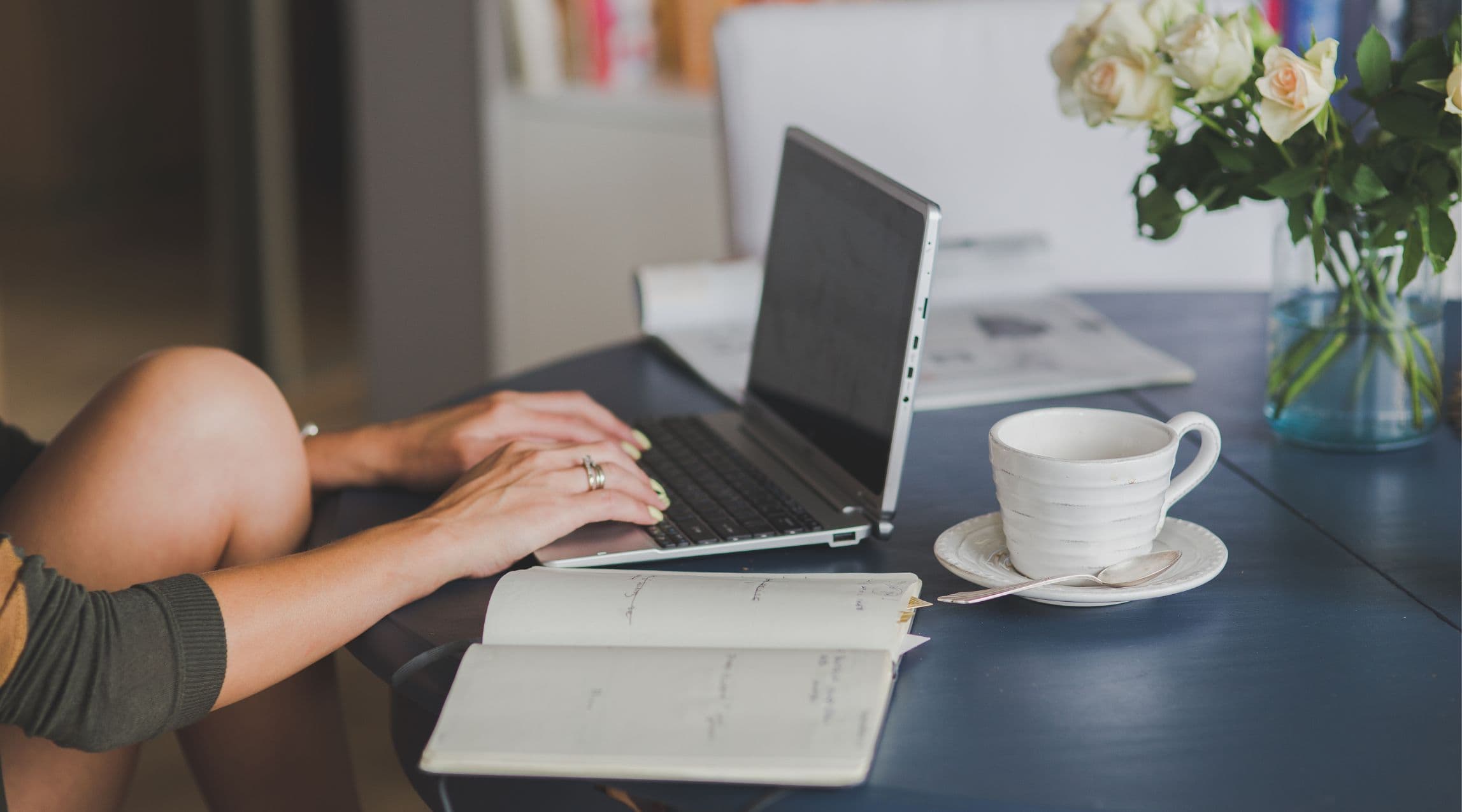 woman typing on laptop at black table